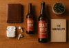 Flat lay of thoughtful gifts for men including a wallet, book, earbuds and craft beer on a wooden surface