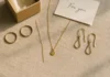 Flat-lay of meaningful jewellery gifts arranged on linen with a handwritten note and gift box