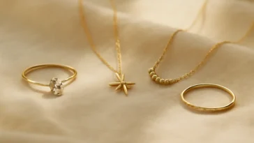 Simbolinių papuošalų dovanų kompozicija: deimantinis žiedas, šiaurinės žvaigždės pakabukas ir kelionės pakabukas ant kreminės lino medžiagos